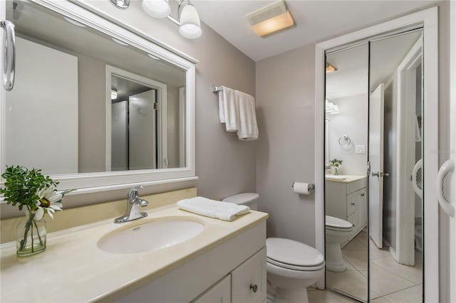 bathroom with tile patterned flooring, vanity, and toilet