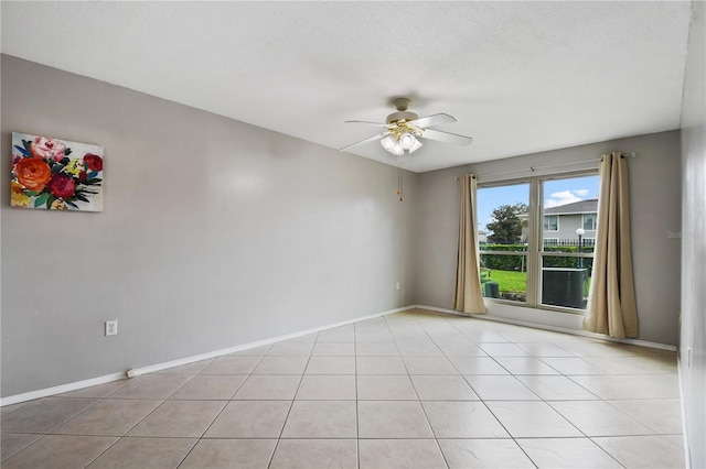 tiled spare room with ceiling fan and a textured ceiling