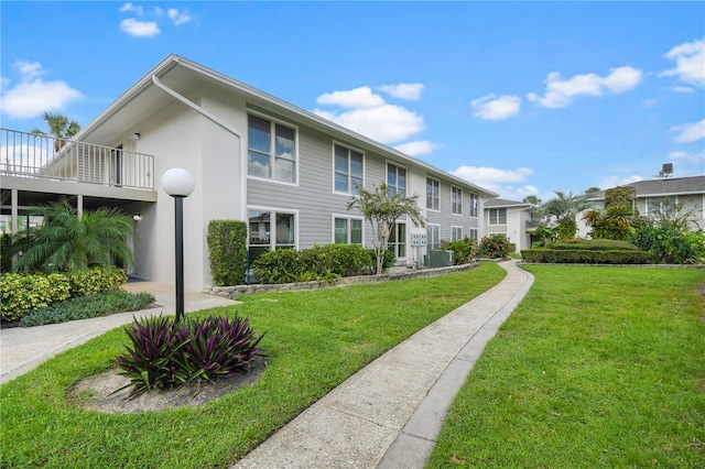 view of front of property featuring cooling unit and a front yard