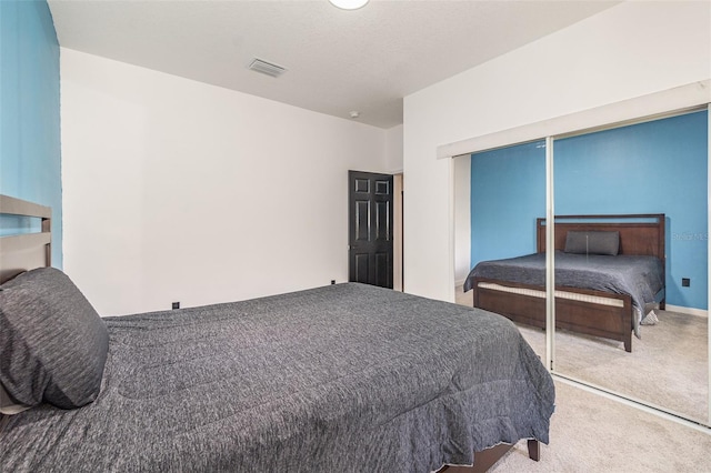 bedroom with light colored carpet and a closet