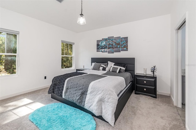 bedroom with light carpet and multiple windows