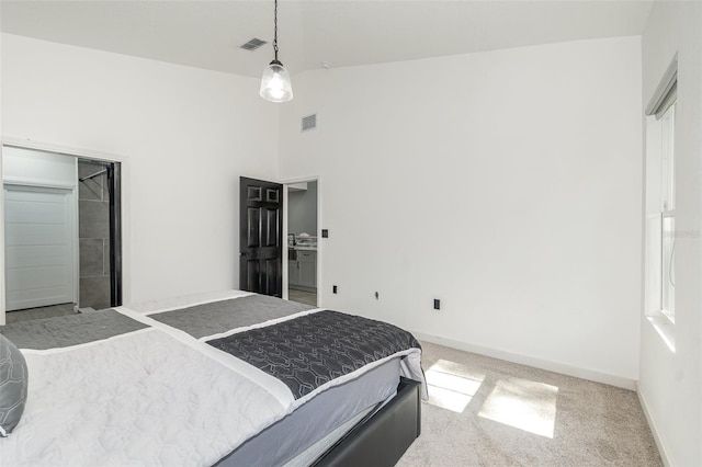 carpeted bedroom with a towering ceiling