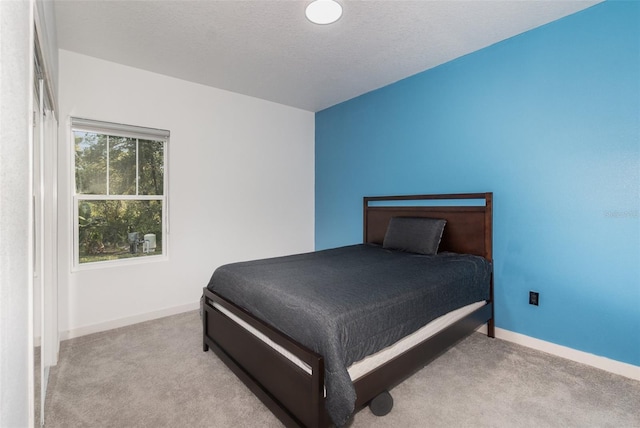 bedroom with light carpet and a textured ceiling