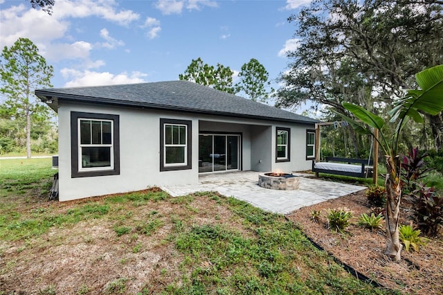 rear view of house with a patio area and an outdoor fire pit