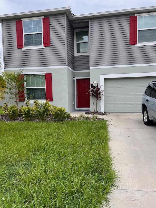 view of front of property with a front yard and a garage