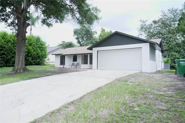 single story home featuring central AC unit and a garage