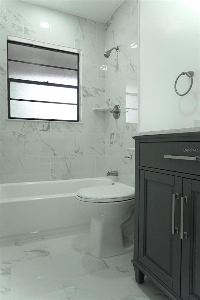 full bathroom featuring tiled shower / bath, vanity, toilet, and a wealth of natural light