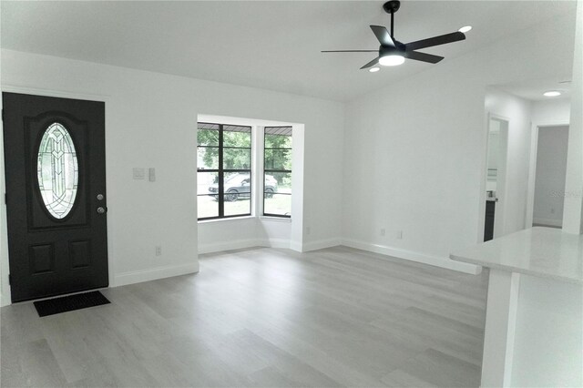 entrance foyer with light hardwood / wood-style floors, ceiling fan, and vaulted ceiling