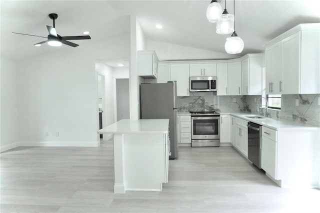 kitchen with sink, white cabinets, vaulted ceiling, appliances with stainless steel finishes, and ceiling fan