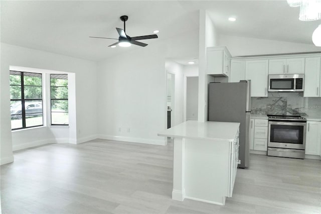 kitchen featuring vaulted ceiling, ceiling fan, stainless steel appliances, and white cabinets