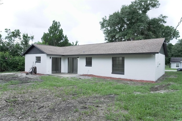 rear view of property featuring a yard