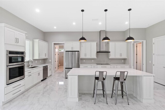 kitchen featuring white cabinets, a large island, stainless steel appliances, and decorative light fixtures