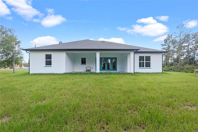 rear view of property with french doors and a yard