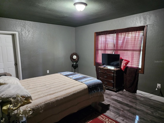 bedroom featuring wood-type flooring and a textured ceiling