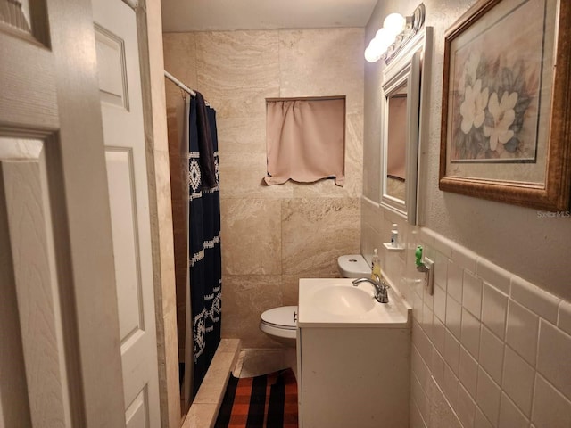 bathroom with tile walls, vanity, curtained shower, and toilet