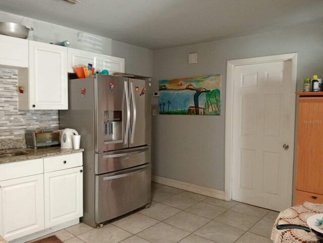 kitchen with white cabinetry, light tile patterned floors, decorative backsplash, and stainless steel refrigerator with ice dispenser