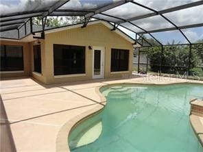 view of pool featuring glass enclosure and a patio