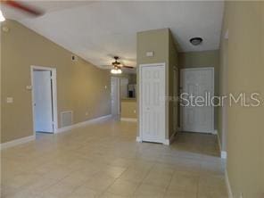 unfurnished room featuring light tile patterned floors, ceiling fan, and lofted ceiling