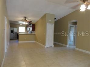 unfurnished living room featuring ceiling fan and lofted ceiling