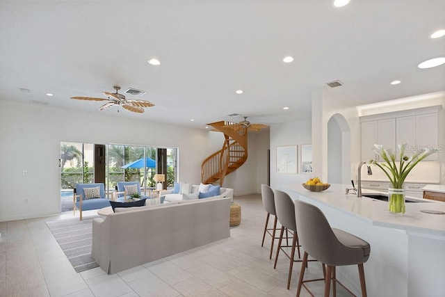 living area with visible vents, recessed lighting, arched walkways, and stairway