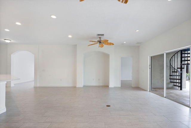 unfurnished room featuring stairs, recessed lighting, baseboards, arched walkways, and a ceiling fan