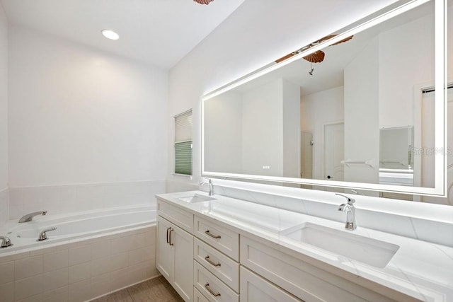 full bathroom with double vanity, a sink, and a garden tub