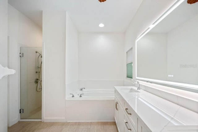 bathroom with vanity, a stall shower, and a bath