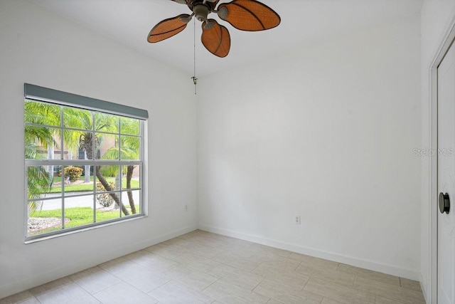 empty room featuring ceiling fan and a wealth of natural light