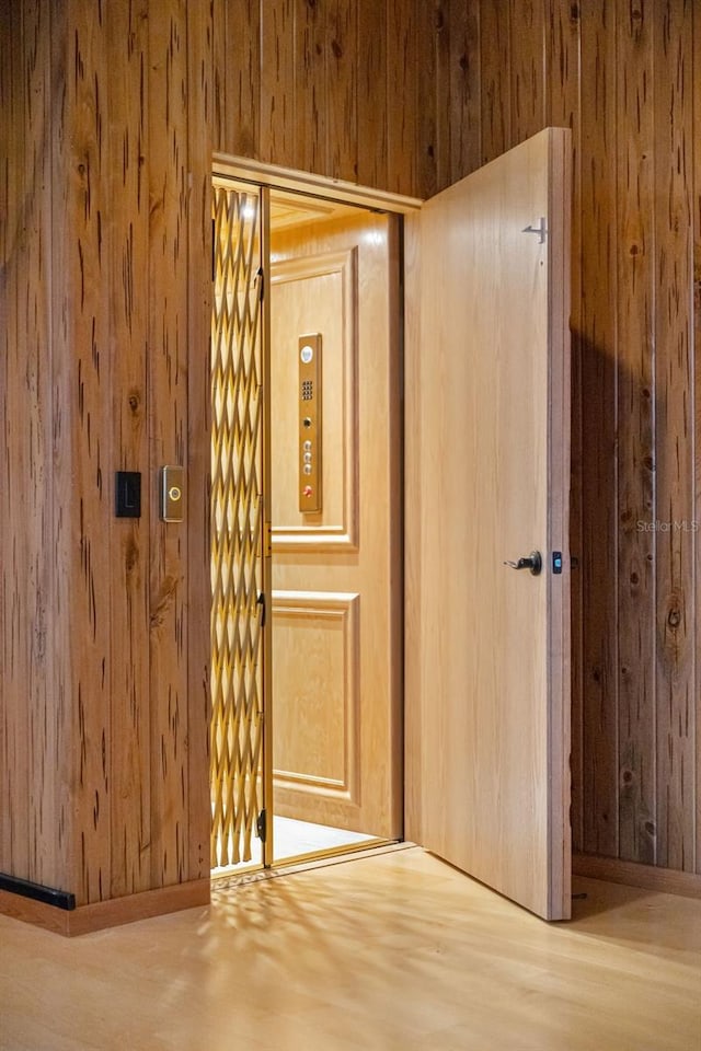 interior space with wood finished floors and wooden walls