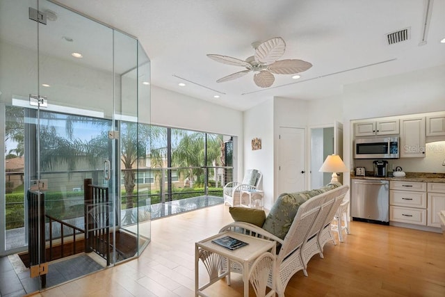 living area featuring a ceiling fan, recessed lighting, light wood-style flooring, and visible vents