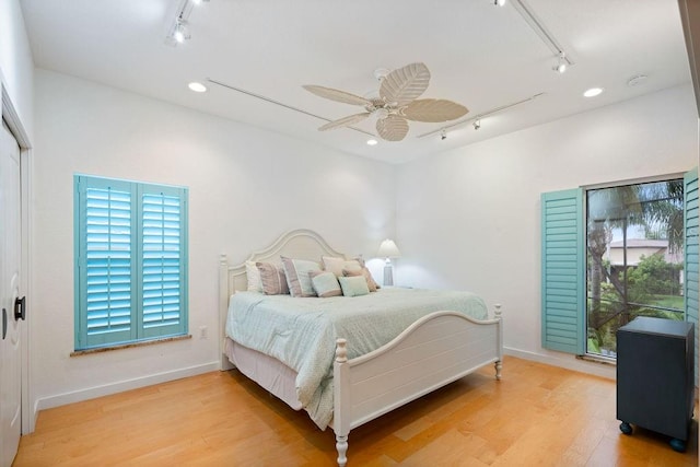 bedroom with ceiling fan, light hardwood / wood-style flooring, and track lighting