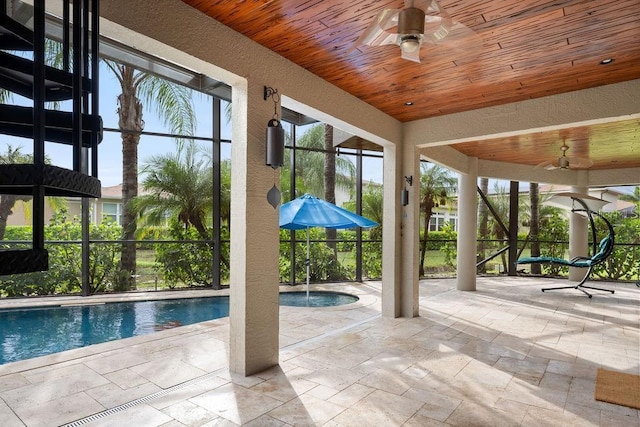 pool featuring a lanai, a patio area, and a ceiling fan