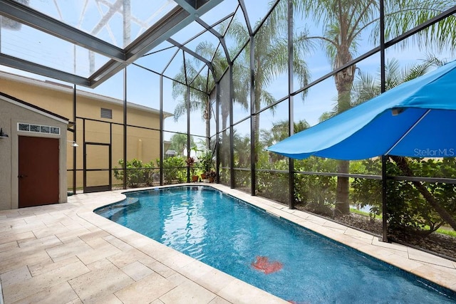 view of swimming pool with glass enclosure and a patio