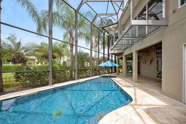 view of swimming pool with glass enclosure and a patio area