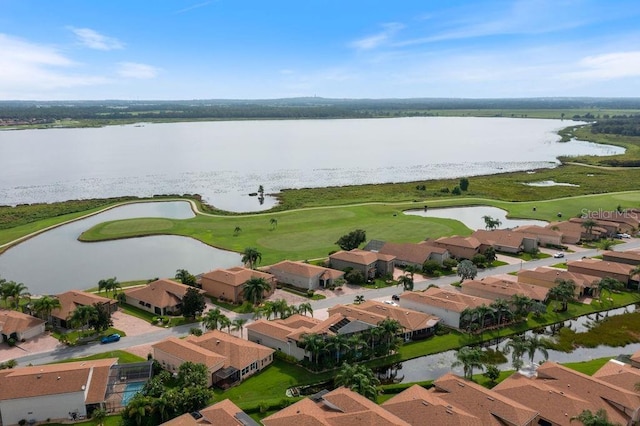 drone / aerial view with a water view, view of golf course, and a residential view