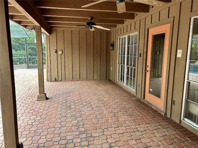 view of patio with ceiling fan and glass enclosure