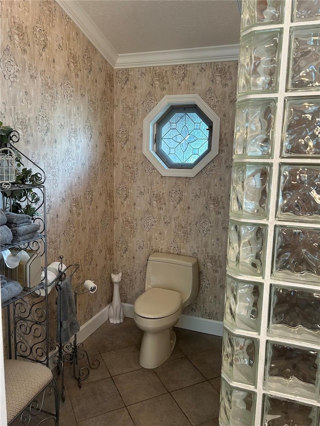 bathroom featuring wallpapered walls, toilet, ornamental molding, baseboards, and tile patterned floors