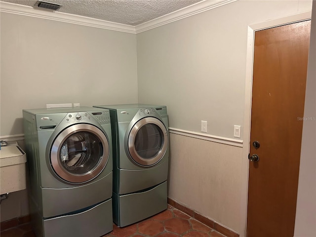 laundry room featuring a wainscoted wall, visible vents, a textured ceiling, washer and dryer, and laundry area