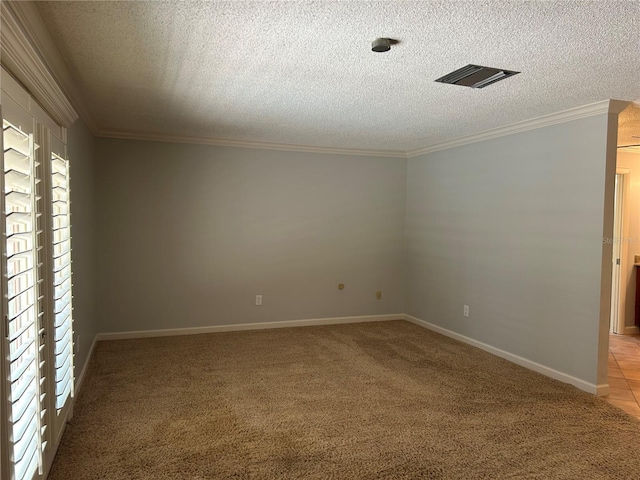 empty room featuring ornamental molding, visible vents, light carpet, and a textured ceiling