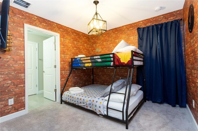 carpeted bedroom with an inviting chandelier and brick wall