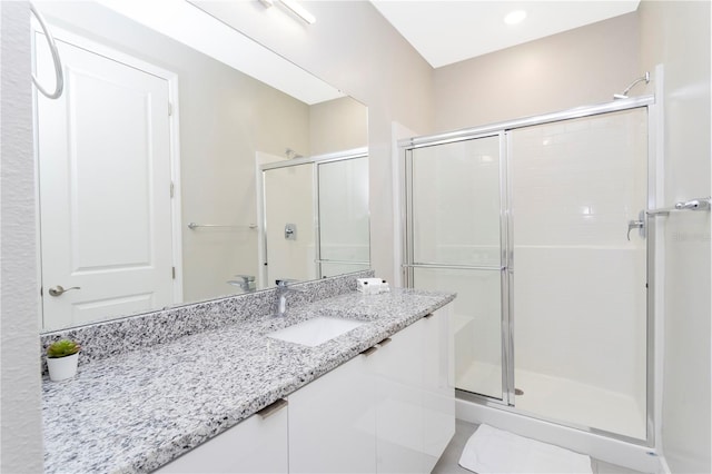 bathroom featuring walk in shower, vanity, and tile patterned floors