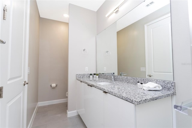 bathroom featuring tile patterned floors, vanity, and toilet