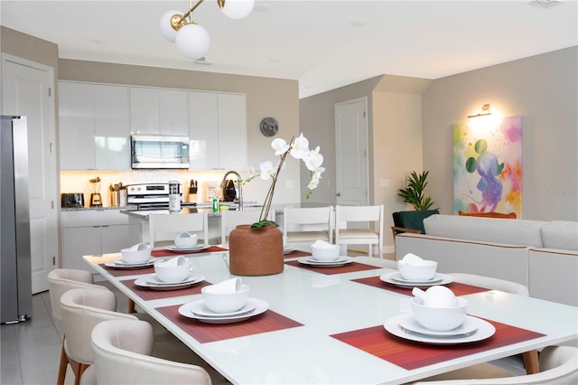 dining room featuring sink and light tile patterned floors