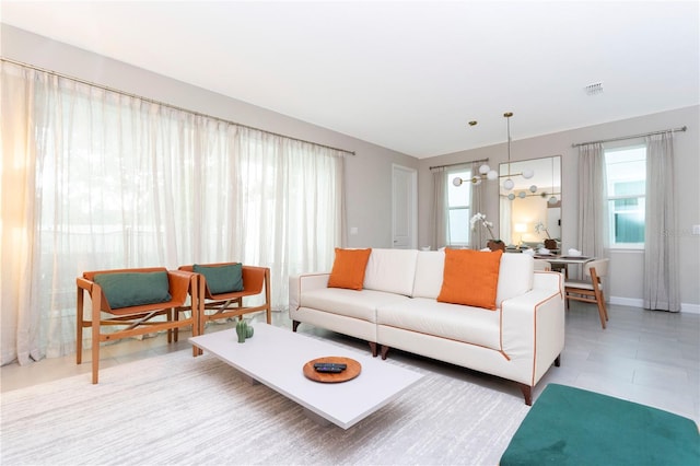 tiled living room with a notable chandelier