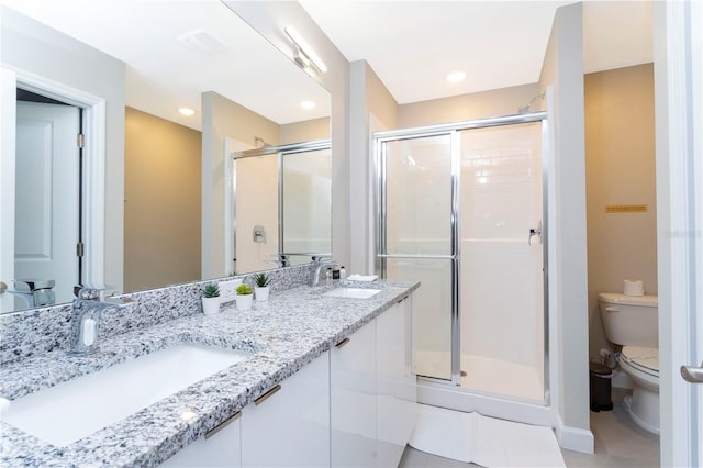 bathroom featuring vanity, a shower with shower door, toilet, and tile patterned floors