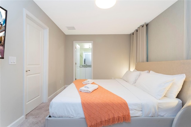 carpeted bedroom featuring ensuite bathroom