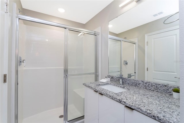 bathroom with vanity and a shower with shower door