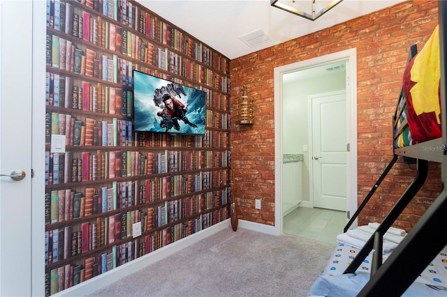 bedroom with light colored carpet and brick wall