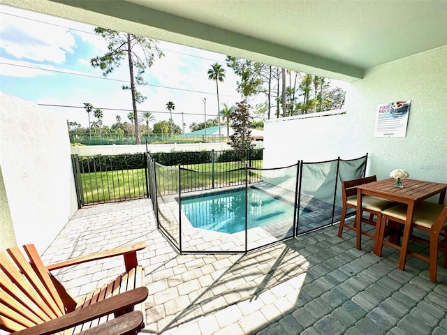 view of pool featuring outdoor dining space, a patio area, fence, and a pool