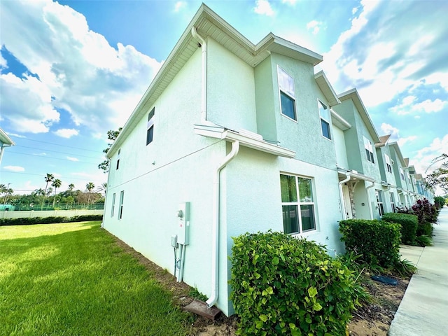 view of property exterior featuring stucco siding and a yard